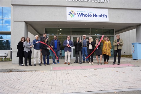 image of staff cutting ceremonial ribbon in front of TCWH office (55 Brown Rd)