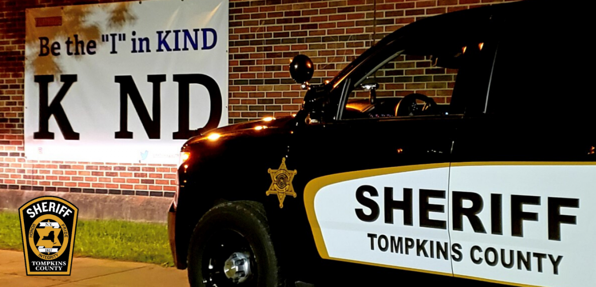 Автомобиль шерифа на фоне плаката «Be the I in Kind»